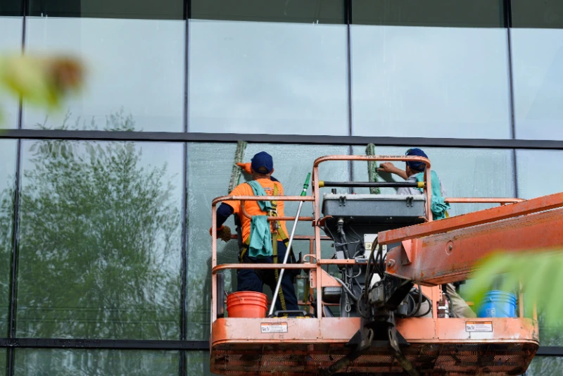 Window cleaners working from a lift on a large glass building