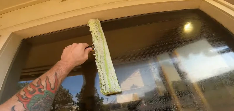 Squeegee being pulled across a window