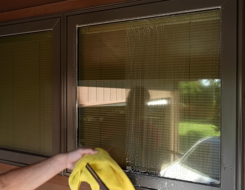 Handheld window vacuum drying a window pane